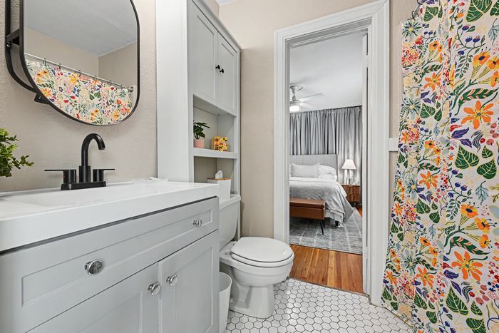 Bathroom in Apartment 3N with floral shower curtain and hex tile floor