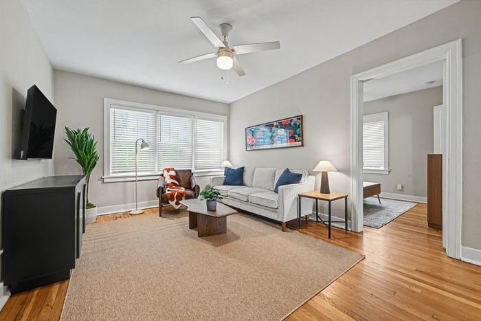 Living room of Apartment 3N with ceiling fan and large window