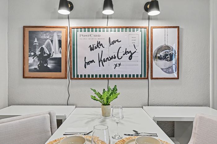 Kansas City postcard gallery wall above the dining table in Apartment 3N