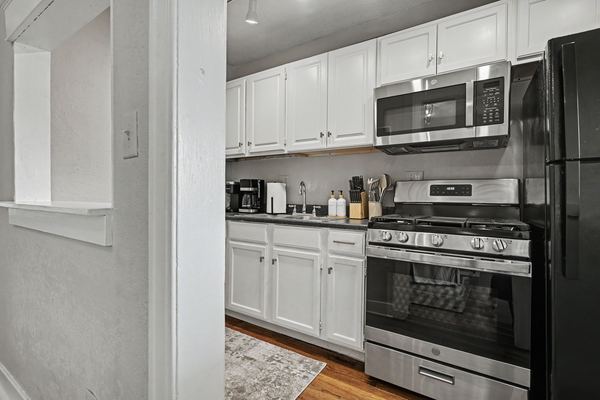 Kitchen in Apartment 3S with white cabinets and gas range